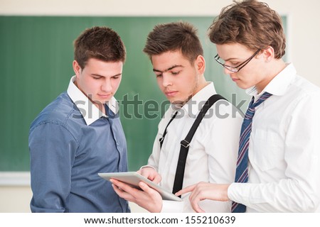 Three young students looking at a tablet pc