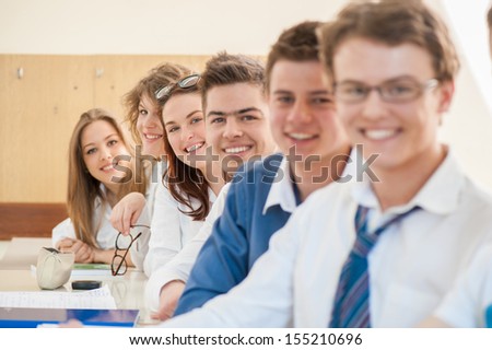 Happy group of students posing and sitting together