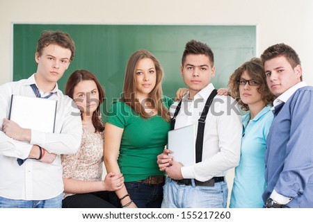 A group of boys and girls in a school classroom posing