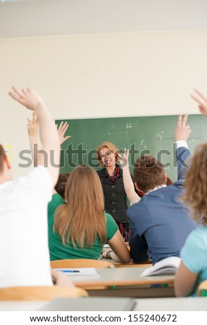 Happy teacher looking at her class students