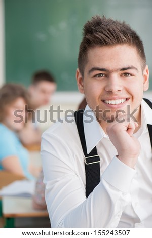 Well dressed high school student posing in a classroom