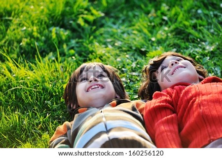 Happy kid enjoying sunny late summer and autumn day in nature on green grass