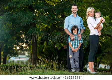 Happy young family standing outside in the park