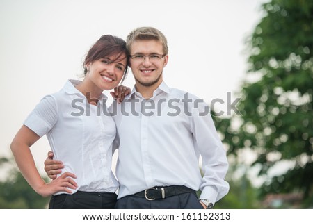 Smiling businessman and businesswoman hugging outside