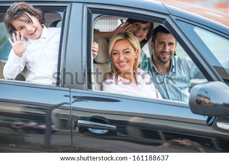 Happy smiling family posing in car