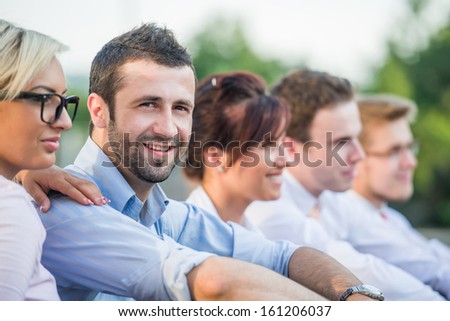 Elegant business people posing sitting in a row