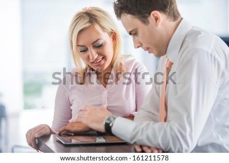 Two happy corporate people at work in an office