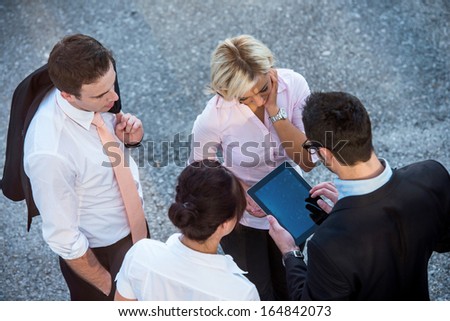 Above view of four corporate people talking on a street