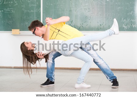 High school student in classroom surrounded with his jumping friends