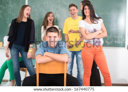 High school student in classroom surrounded with his jumping friends