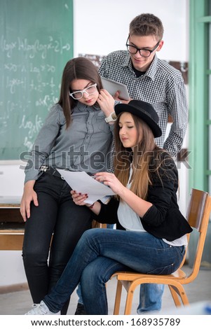 Three smart looking students reading together