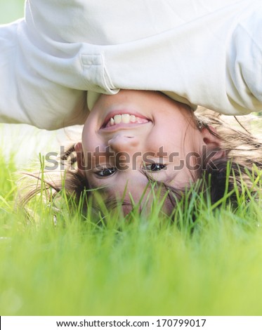 Portraits Of Happy Kids Playing Upside Down Outdoors In Summer Park