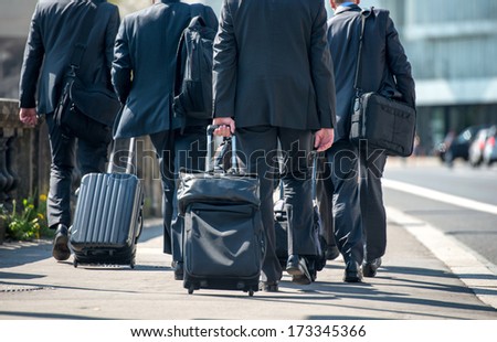 A Group Of Businessmen Pulling Suitcases With Luggage