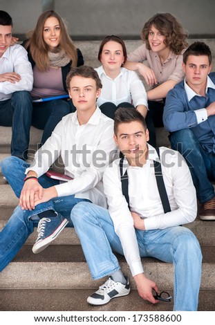 Happy group of students sitting in a school hall