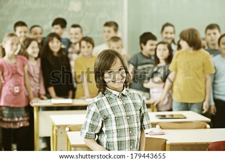 Cheerful group of kids at school room having education activity