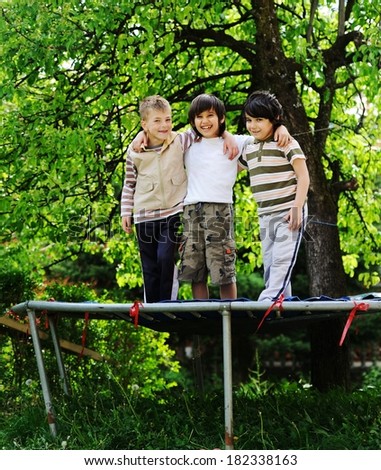 Cheerful kids having fun jumping on trampoline