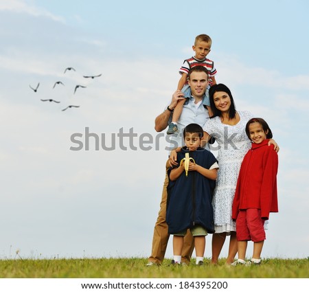 Happy young mother and father with three sons in nature
