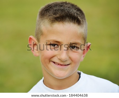 Happy little boy on summer grass meadow in nature having happy time
