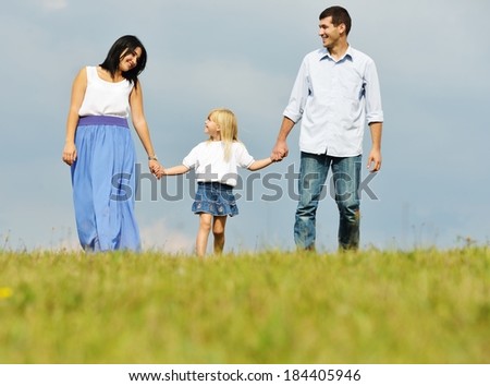 Happy young family on green summer grass meadow having fun