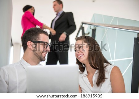 Couple of happy business people with laptop