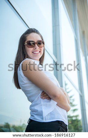 Executive woman with sunglasses posing outisde business building