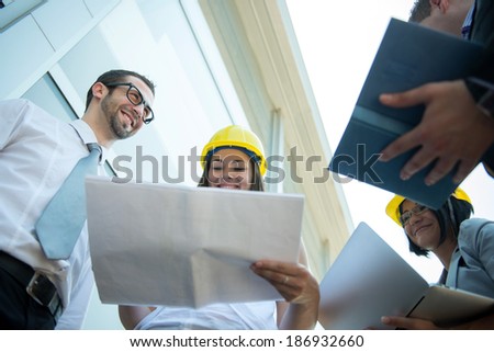 Business team reviewing plans in front of corporate building