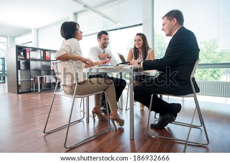 Group of people teamworking sitting around table