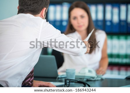 Man handing papers to female colleague in office