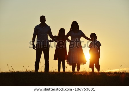 People silhouettes on summer sunset meadow