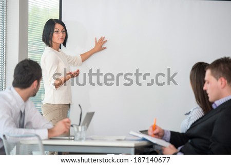 Business woman giving presentation to a team of her colleagues