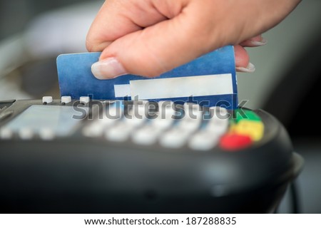 Hand swiping debit card on pos terminal