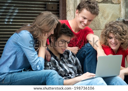 Adolescents using a notebook pc outdoors