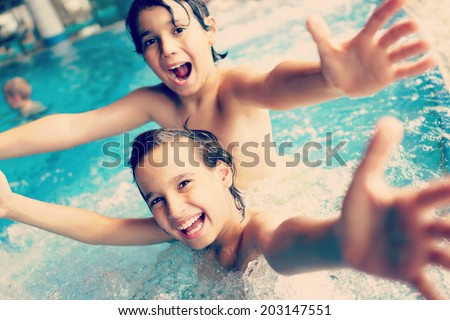 Two happy kids having fun on summer pool (colorized effect)
