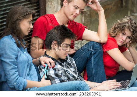 Group of young people reading on a notebook pc