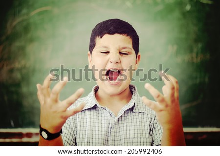 Angry and upset pupil at school classroom
