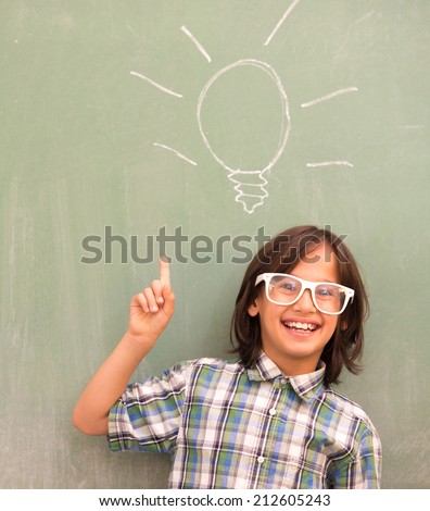 Smart schoolboy on school board with bulb for idea