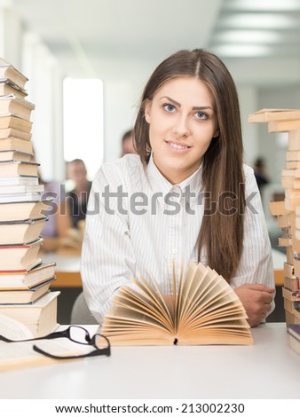 College girl student on university campus with open book in hands