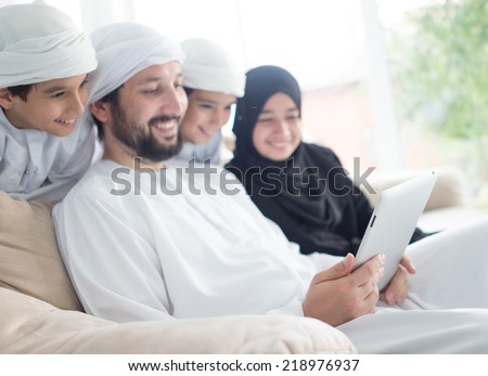 Middle eastern family at home on couch using tablet