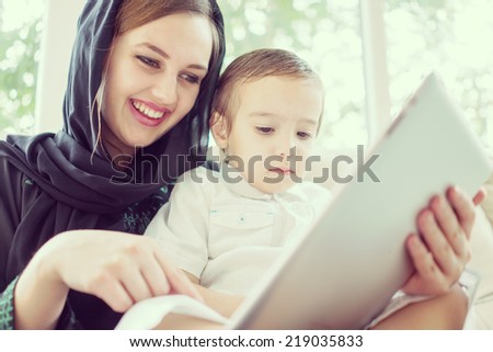 Beautiful Arabic family, mother and cute baby with tablet