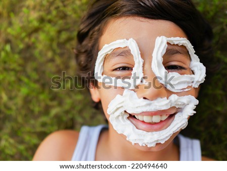 Cute little boy with cream making smiley face smiling