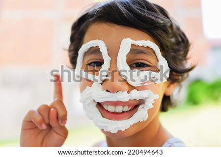 Cute little boy with cream making smiley face smiling