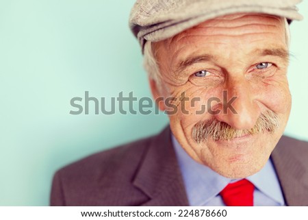 Portrait of a smiling and confident senior good looking business man with hat