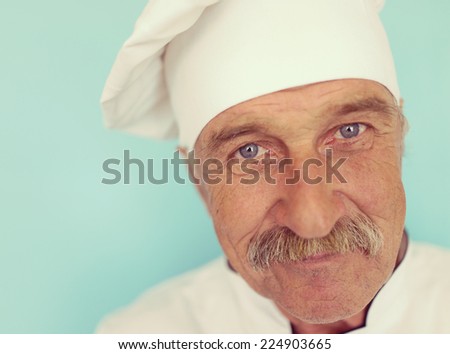 Elderly chef in white cook uniform