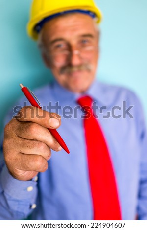 Happy smiling senior engineer closeup portrait with pen writing on abstract background copy space