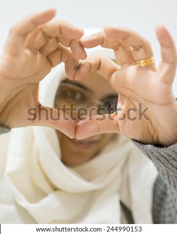 Muslim Arabic woman with heart shaped love symbol hands