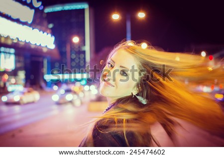 Girl walking on the night city street in slow motion (Note: this image is in motion, without still focus)