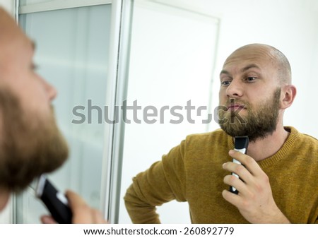 Elegant young handsome man making beard perfect