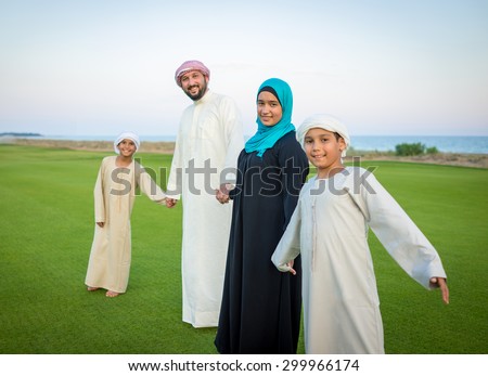 Arabic family on green meadow in nature