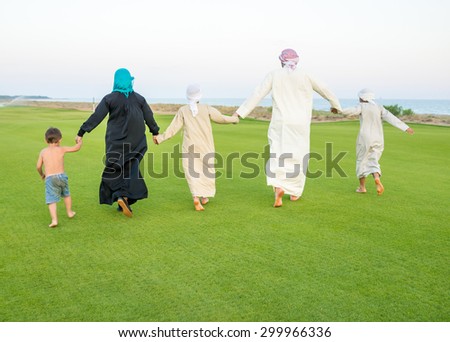 Arabic family on green meadow in nature