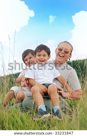 Happy three children in nature with grandmother
